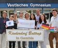 Der Schulleiter, die Schülervertretung, die AG-Lehrerin sowie vier Schüler übergeben den Spendenscheck an den Vorsitzenden des Vereins Kinderdorf Bottrop in Gambia, Wolfgang Gerrits (l.).