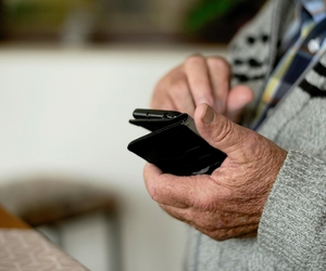 Ein Senior hält ein Handy