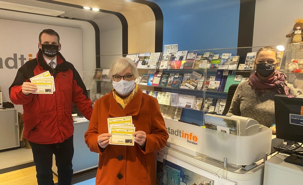 Bürgermeister Tobias Stockhoff hat in der Stadtinfo „Kultur-Karten der Solidarität“ gekauft. Mit dabei: Stadtagentur-Leiterin Sabine Fischer (m.) und Barbara Seppi