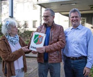 Maria Reidick-Rominski übergibt ein Schild an Jörg Middelhoff (m.). Magnus Thesing steht dabei.