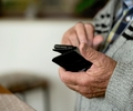 Ein Senior hält ein Handy